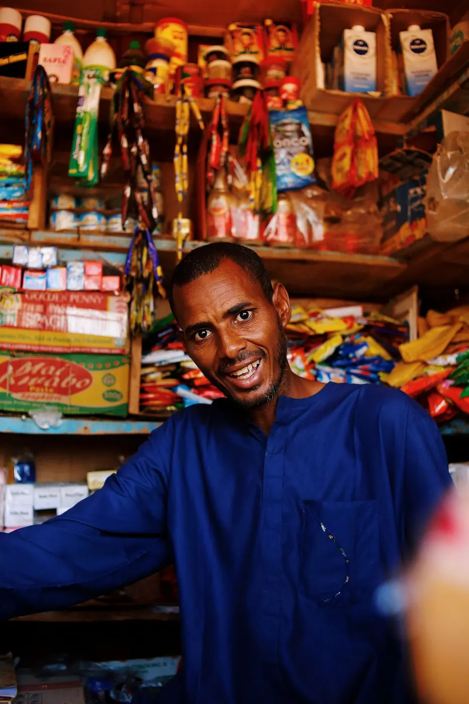 A smiling shopkeeper in his grocery store