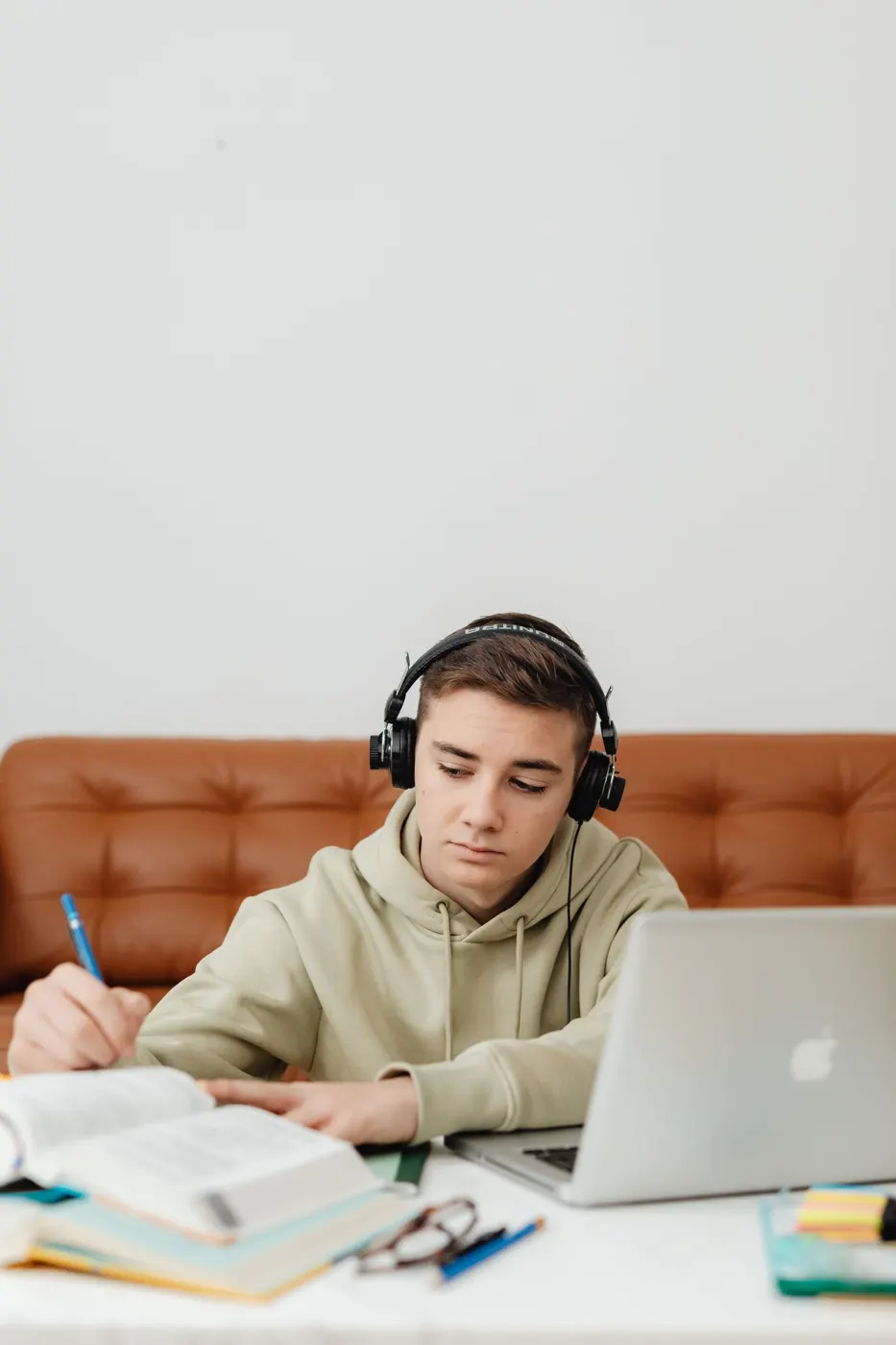 A student with headphones studying at a laptop